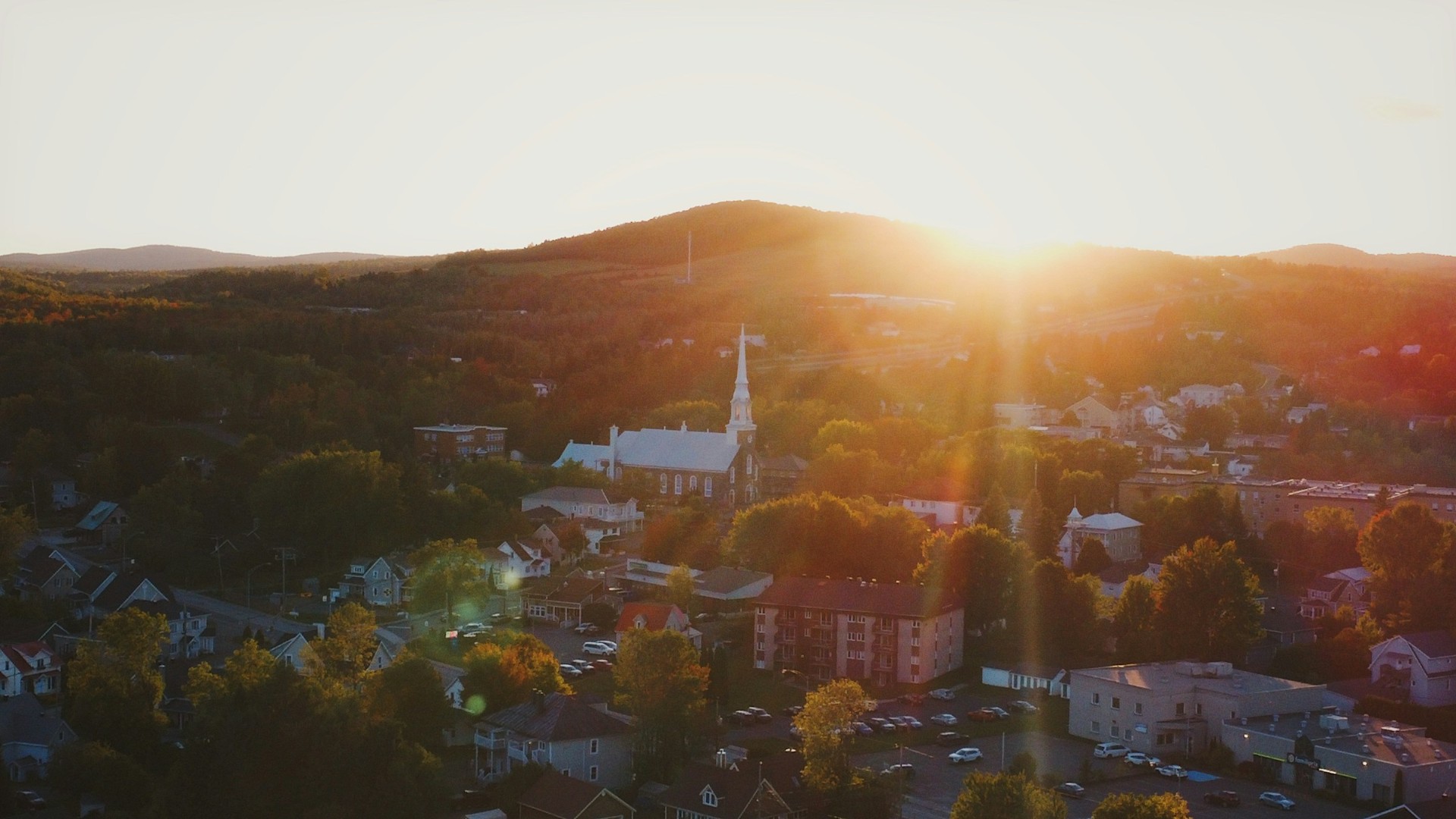 Small-town main street at golden hour with a courthouse in the distance